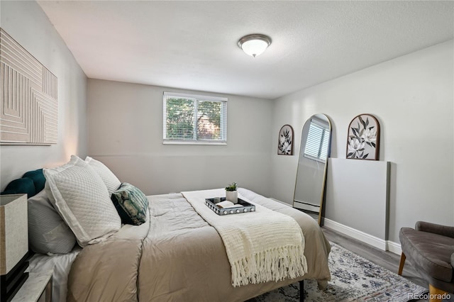 1390 Everett Ct Unit 105, Lakewood, CO 80215 - bedroom with multiple windows, wood finished floors, baseboards, and baseboard heating