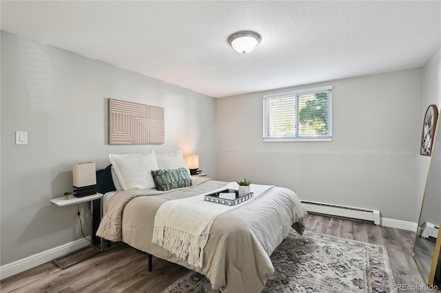 1390 Everett Ct Unit 105, Lakewood, CO 80215 - bedroom with baseboard heating, wood finished floors, and baseboards