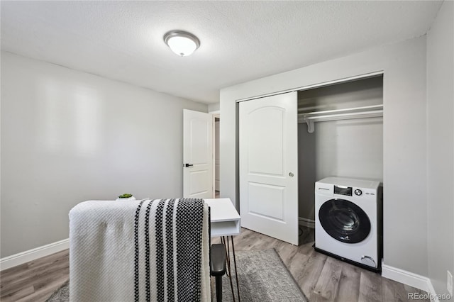 1390 Everett Ct Unit 105, Lakewood, CO 80215 - laundry room featuring washer / clothes dryer, wood finished floors, baseboards, and a textured ceiling