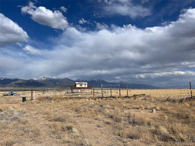 view of yard featuring a view of rural / pastoral area, a mountain view, and fence