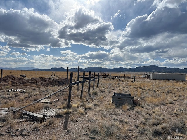 view of yard with a mountain view, a view of rural / pastoral area, and fence