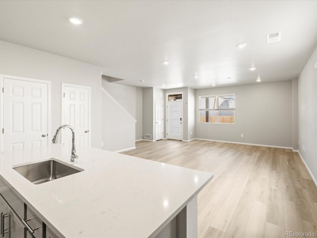 764 N Tempe St, Aurora, CO 80018 - kitchen with a sink, open floor plan, light wood-style flooring, baseboards, and visible vents