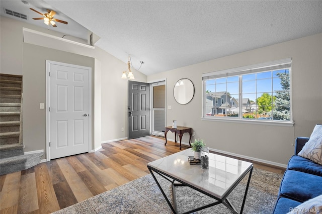 20858 E Progress Ave, Centennial, CO 80015 - living room featuring stairs, a textured ceiling, vaulted ceiling, wood finished floors, and a ceiling fan