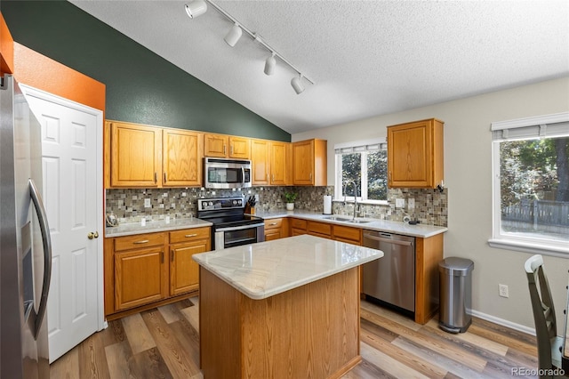 20858 E Progress Ave, Centennial, CO 80015 - kitchen featuring stainless steel appliances, light wood-style floors, backsplash, a textured ceiling, and lofted ceiling