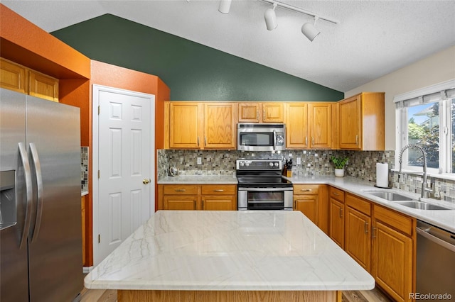 20858 E Progress Ave, Centennial, CO 80015 - kitchen with stainless steel appliances, vaulted ceiling, backsplash, a center island, and track lighting