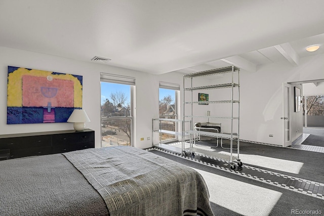 bedroom featuring visible vents, beamed ceiling, and carpet floors