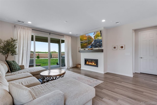 944 Alpine Ridge St, Erie, CO 80516 - living area featuring a glass covered fireplace, wood finished floors, baseboards, and recessed lighting
