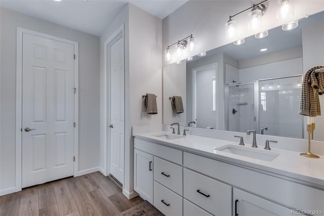 944 Alpine Ridge St, Erie, CO 80516 - full bathroom featuring double vanity, a stall shower, wood finished floors, and baseboards
