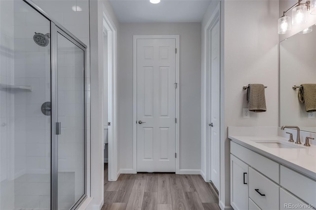 944 Alpine Ridge St, Erie, CO 80516 - full bathroom with a stall shower, vanity, wood finished floors, and toilet