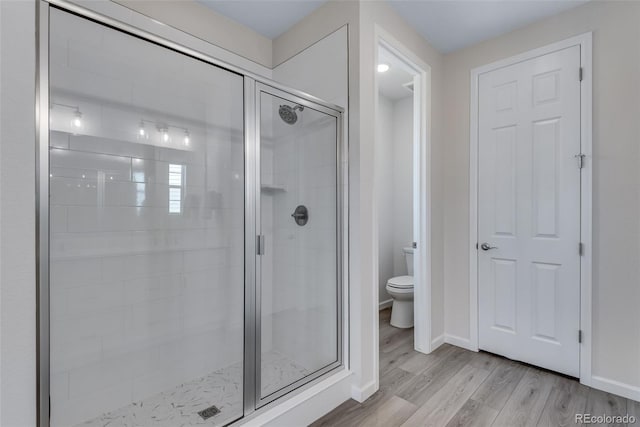 944 Alpine Ridge St, Erie, CO 80516 - bathroom with toilet, a stall shower, wood finished floors, and baseboards