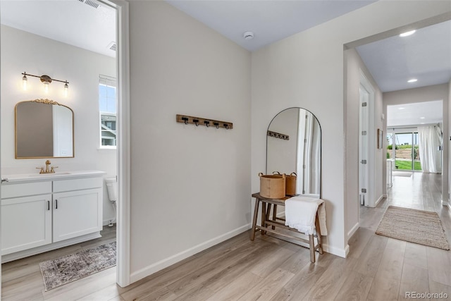 944 Alpine Ridge St, Erie, CO 80516 - corridor featuring light wood-style floors, a sink, and baseboards