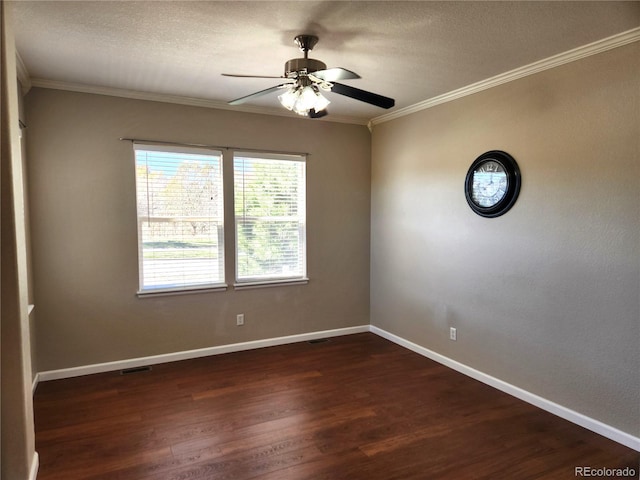 empty room featuring dark wood finished floors, visible vents, a ceiling fan, crown molding, and baseboards