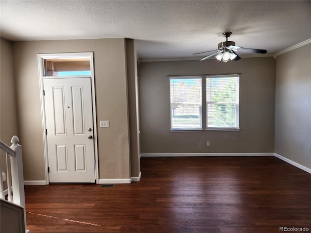 foyer with dark wood-style floors, visible vents, crown molding, baseboards, and ceiling fan
