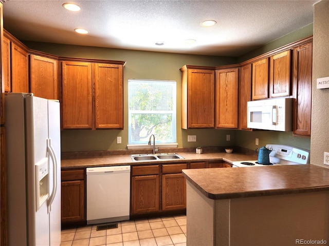 kitchen with a textured ceiling, white appliances, sink, and light tile patterned floors