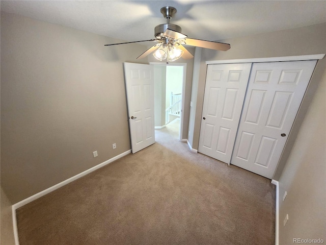 unfurnished bedroom with ceiling fan, light colored carpet, and a closet