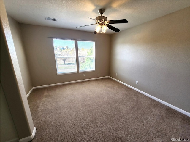 carpeted spare room with ceiling fan and a textured ceiling