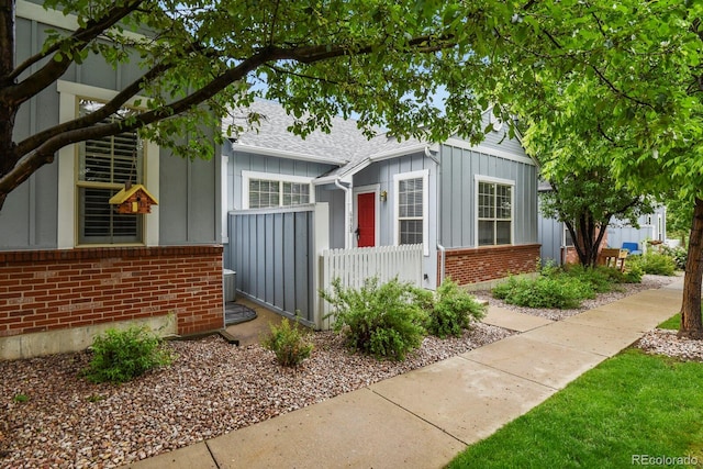6868 Los Reyes Cir, Colorado Springs, CO 80918 - view of front of house featuring brick siding, board and batten siding, and roof with shingles