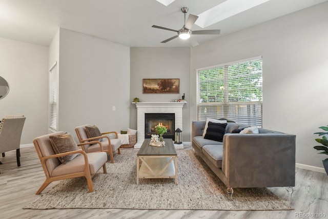 6868 Los Reyes Cir, Colorado Springs, CO 80918 - living room featuring baseboards, wood finished floors, ceiling fan, and a brick fireplace