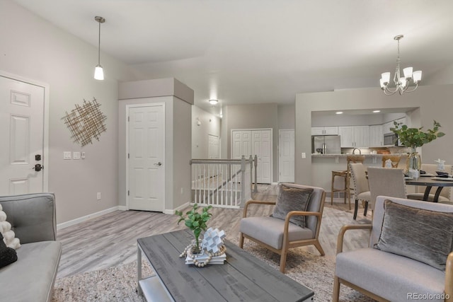 6868 Los Reyes Cir, Colorado Springs, CO 80918 - living room with a chandelier, light wood-style flooring, and baseboards