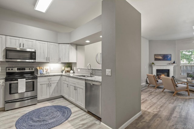 6868 Los Reyes Cir, Colorado Springs, CO 80918 - kitchen with appliances with stainless steel finishes, a sink, light stone counters, decorative backsplash, and baseboards