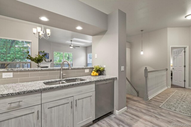 6868 Los Reyes Cir, Colorado Springs, CO 80918 - kitchen with stainless steel dishwasher, a sink, light wood finished floors, a ceiling fan, and light stone countertops