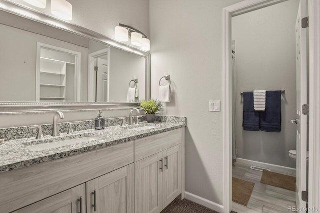 6868 Los Reyes Cir, Colorado Springs, CO 80918 - full bathroom featuring baseboards, double vanity, and toilet
