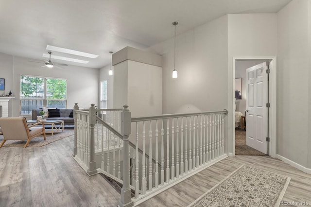 6868 Los Reyes Cir, Colorado Springs, CO 80918 - corridor featuring wood finished floors, a skylight, baseboards, and an upstairs landing