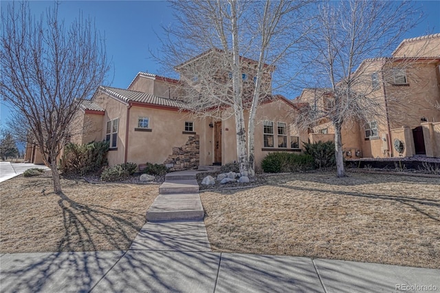 mediterranean / spanish-style house featuring a tiled roof and stucco siding