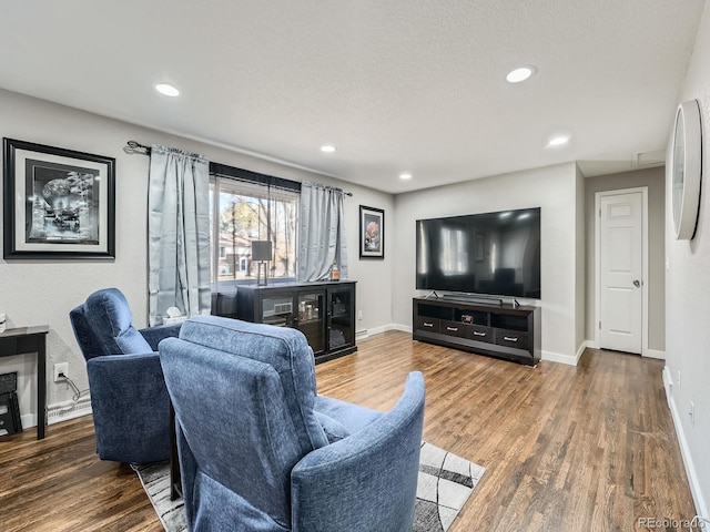 living room with wood-type flooring and a textured ceiling