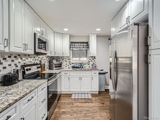 kitchen featuring stainless steel appliances, dark hardwood / wood-style floors, white cabinets, and decorative backsplash