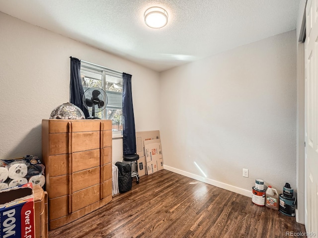 bedroom featuring dark hardwood / wood-style flooring and a textured ceiling