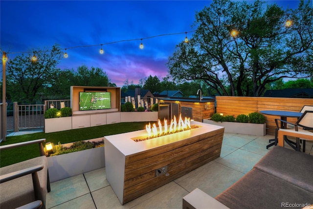 patio terrace at dusk featuring a fire pit