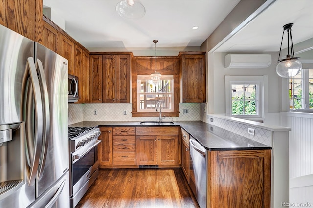 kitchen with pendant lighting, wood-type flooring, stainless steel appliances, and sink