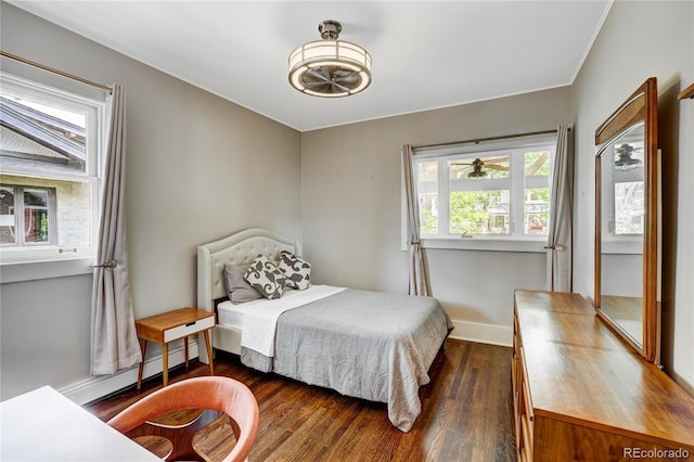 bedroom with a baseboard heating unit and dark wood-type flooring