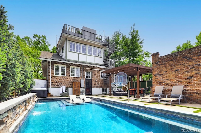 rear view of property with pool water feature and a balcony