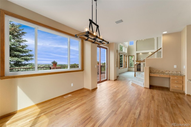 6323 S Sicily Way, Aurora, CO 80016 - unfurnished dining area with light wood-style floors, stairs, and baseboards