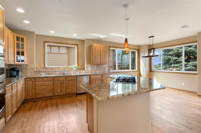 6323 S Sicily Way, Aurora, CO 80016 - kitchen featuring appliances with stainless steel finishes, light wood-type flooring, a kitchen island, decorative backsplash, and light stone counters