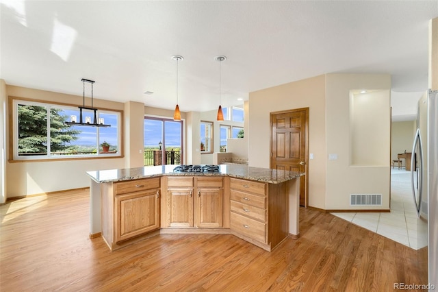 6323 S Sicily Way, Aurora, CO 80016 - kitchen with light wood finished floors, light stone countertops, appliances with stainless steel finishes, and plenty of natural light