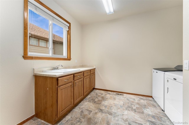 6323 S Sicily Way, Aurora, CO 80016 - laundry area featuring independent washer and dryer, baseboards, stone finish floors, and cabinet space