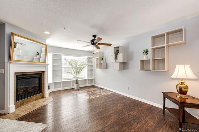 living room with ceiling fan, a tile fireplace, wood finished floors, baseboards, and recessed lighting