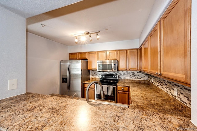kitchen with a sink, backsplash, stainless steel appliances, and a peninsula