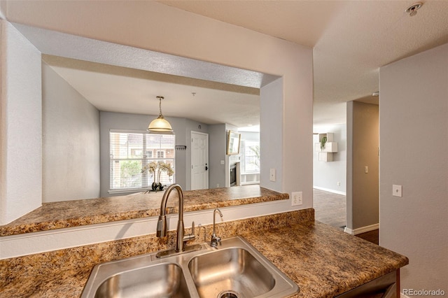 kitchen with baseboards, hanging light fixtures, and a sink