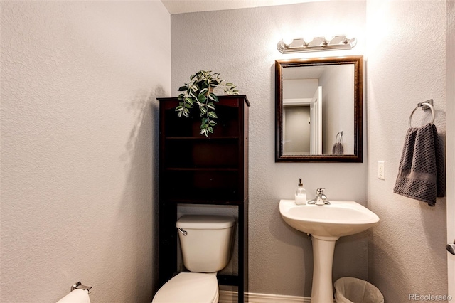 half bathroom featuring a sink and toilet