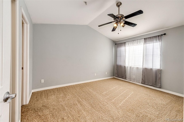 spare room with a ceiling fan, baseboards, vaulted ceiling, and light carpet