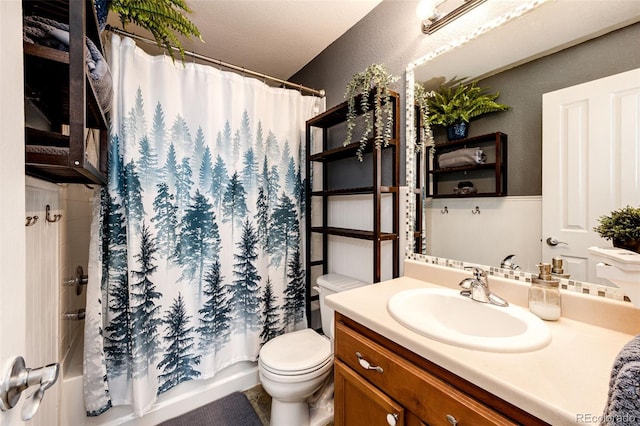 bathroom featuring vanity, a textured wall, shower / bath combo with shower curtain, and toilet