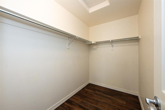 walk in closet featuring attic access and dark wood finished floors