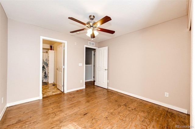 unfurnished bedroom with a ceiling fan, baseboards, visible vents, and wood finished floors