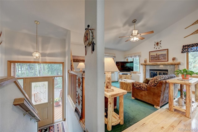 living room featuring hardwood / wood-style flooring, lofted ceiling, ceiling fan, and a premium fireplace