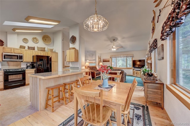 dining area with light hardwood / wood-style flooring and ceiling fan with notable chandelier