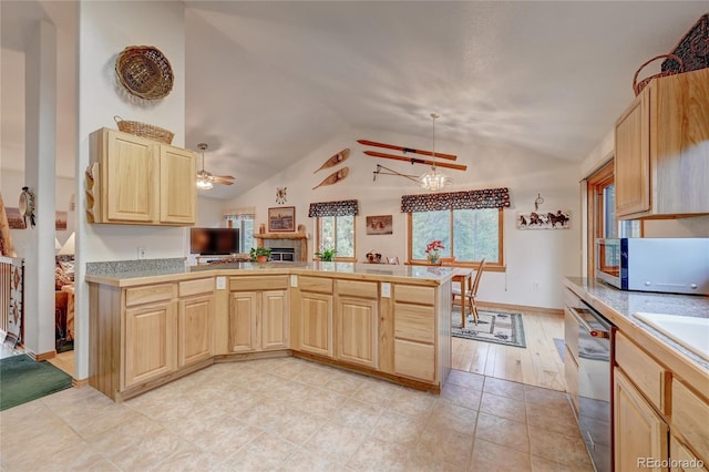 kitchen featuring stainless steel dishwasher, decorative light fixtures, light brown cabinets, and lofted ceiling